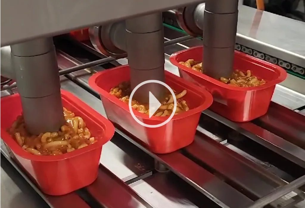 AG-Dosiermaschine dosiert Nudeln in drei nebeneinanderliegende Trays